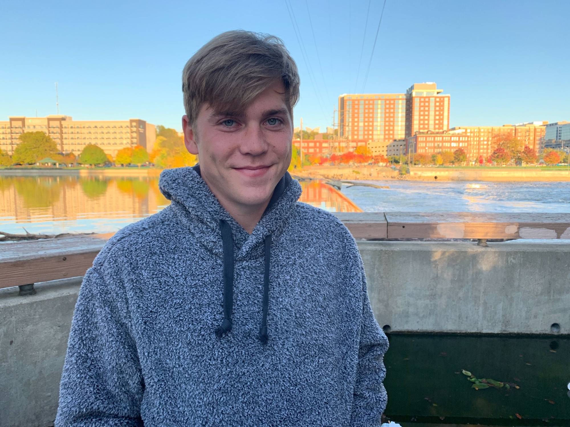 Headshot of Nick Vander Stelt  with the cityscape of Muskegon behind him.
